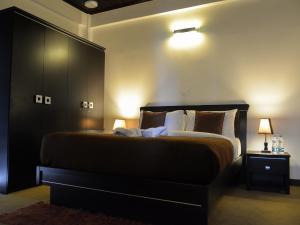 1 dormitorio con 1 cama grande y cabecero negro en Panoramic Holiday Apartment / Seagull Complex | Nuwara Eliya, en Nuwara Eliya