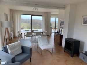 a living room with a table and chairs and a tv at le pré du poney in Spa
