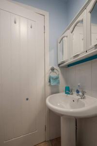 ein weißes Bad mit einem Waschbecken und einer Dusche in der Unterkunft Brucefield Avenue in Dunfermline