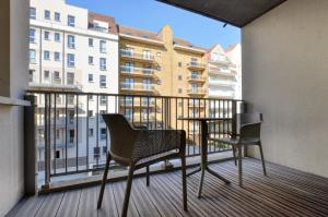 a balcony with two chairs and a table on a balcony at Evancy Etoile Des Dunes in Bray-Dunes