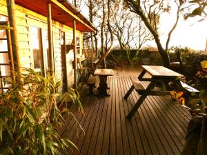 una terraza de madera con mesa de picnic y banco en Sunset Lodge, en Kingsbridge