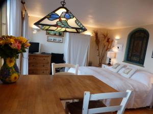 Un dormitorio con una cama y una mesa con un jarrón de flores en Sunset Lodge en Kingsbridge