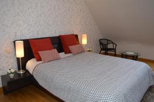 una camera da letto con un grande letto con cuscini rossi di Le Clos du Vieux Port a Véretz