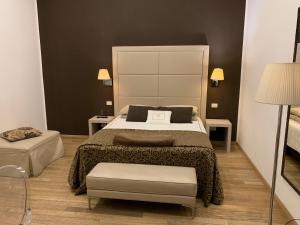 レッジョ・ディ・カラブリアにあるSuite 70のベッドルーム1室(ベッド1台、テーブル2台、ランプ付)