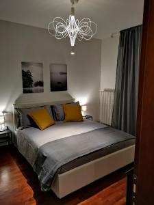 ein Schlafzimmer mit einem Bett mit gelben Kissen und einem Kronleuchter in der Unterkunft Horus apartment in Padua