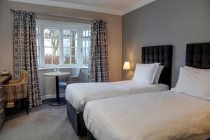 una camera d'albergo con due letti e una finestra di Wild Pheasant Hotel & Spa a Llangollen
