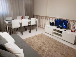 ペニシェにあるPeniche holiday homeのリビングルーム(テレビ、テーブル、椅子付)
