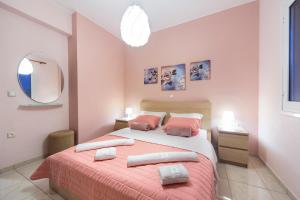 a bedroom with a bed with two pillows and a mirror at Omega Comfy Apartments in Almyrida