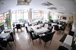 a restaurant with white tables and chairs and windows at Arma Hotel in Manisa +20 photos