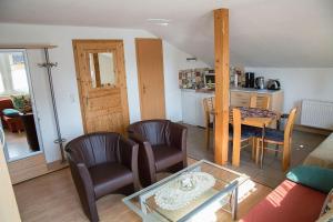 a living room with a table and chairs and a kitchen at Apartment der Villa Elsa in Dresden