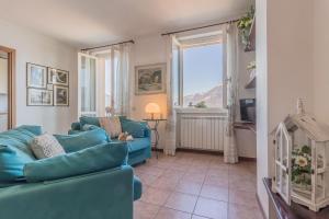 ein Wohnzimmer mit zwei blauen Sofas und einem Fenster in der Unterkunft Il Tramonto sul lago Varenna in Varenna
