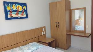 une chambre avec un lit, une armoire et un miroir dans l'établissement FLAT VILA DO MAR, à Aquiraz 19 autres photos
