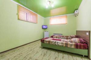 カバルジンカにあるGuest House Abrikosの緑の壁のベッドルーム1室(ベッド1台付)