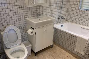 a bathroom with a toilet and a sink and a tub at American Village Resort in Taipei