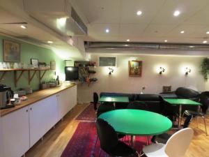 una sala de reuniones con mesa verde y sillas en Hostel Bed & Breakfast, en Estocolmo