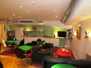 Habitación con sofás, mesas y cocina. en Hostel Bed & Breakfast, en Estocolmo