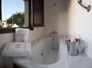 baño blanco con bañera y ventana en Palacio de Santa Inés en Granada