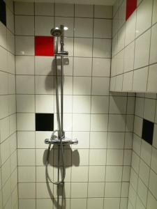 prysznic z wężem przymocowanym do ściany wyłożonej kafelkami w obiekcie Hostel Bed & Breakfast w Sztokholmie