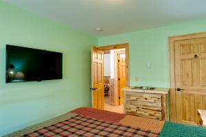 a bedroom with a bed and a television on the wall at Cobble Mountain Lodge in Lake Placid