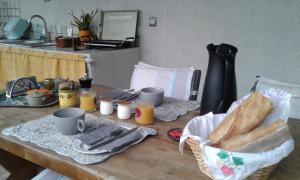 un tavolo con pane e un cesto di cibo sopra di Michèle et Didier Lin a Saint-Laurent-dʼAigouze