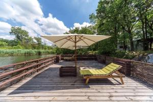 a chair and an umbrella on a wooden boardwalk at База отдыха Дубки in Orlovshchina