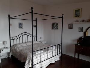 a black four poster bed in a bedroom at Al Sandalyon in Quartu SantʼElena