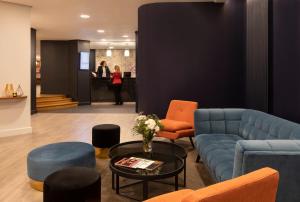 a lobby with a couch and chairs and a table at Citadines Trocadéro Paris in Paris