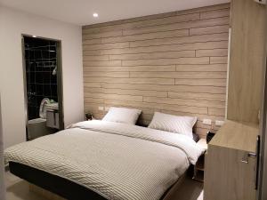 una camera da letto con un letto grande con testiera in legno di Chingya House a Beigan