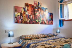 カーラゴノネにあるカーサ グステゥイのベッドルーム1室(ベッド1台付)が備わります。壁には絵画が飾られています。