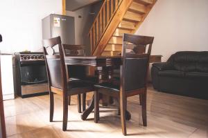 a dining room table with two chairs and a couch at Cabañas Puerta del Lago in Licán Ray