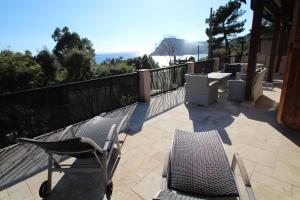 a patio with two chairs and a table and a table and chairs at Résidence Le Golfe Bleu in Rayol-Canadel-sur-Mer