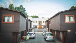 two cars parked in a parking lot between two buildings at Cabañas Puerta del Lago in Licán Ray