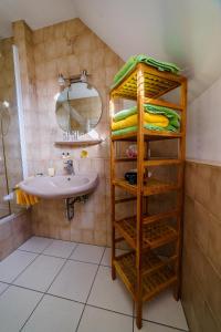 ein Badezimmer mit einem Waschbecken und einem Regal mit Handtüchern in der Unterkunft Moseltalblick in Bernkastel-Kues