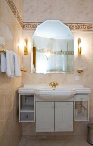 ein Badezimmer mit einem weißen Waschbecken und einem Spiegel in der Unterkunft Pension Clara in Wattens