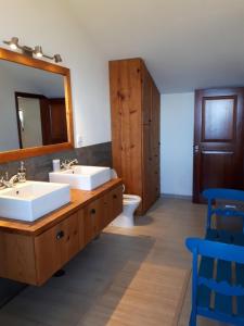 a bathroom with two sinks and a mirror and a toilet at Au petit Madère in Prazeres