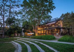 a house with a curved road in front of it at Kaomai Lanna Resort in San Pa Tong