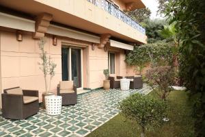 a patio with chairs and plants in front of a building at The Ruby Apartment with Private Swimming Pool - Hivernage Quarter - By Goldex Marrakech in Marrakesh