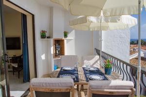 a table and chairs on a balcony with an umbrella at Riviera Playa in Mijas Costa