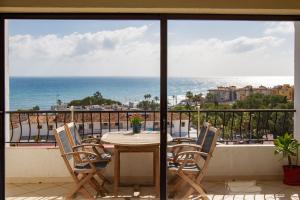 stół i krzesła na balkonie z widokiem na ocean w obiekcie Riviera Playa w mieście Mijas Costa