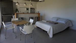 sypialnia z łóżkiem, stołem i krzesłami w obiekcie Barrancas Al Mar w mieście Puerto Madryn