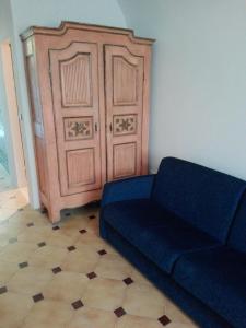 Sofá azul en una habitación con puerta grande en Le Ortensie, en Dolcedo