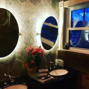 a bathroom with two sinks and two mirrors at Suites North Hatley in North Hatley