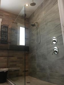uma casa de banho com um chuveiro e uma porta de vidro em Suites North Hatley em North Hatley