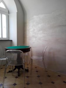 a table and two chairs in a room at Le Ortensie in Dolcedo