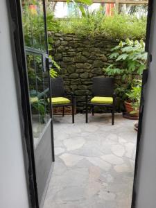 a doorway to a patio with two chairs and a stone wall at Le Ortensie in Dolcedo