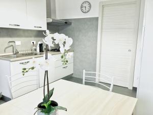 a kitchen with white cabinets and a vase with white flowers at My ROMAN DREAM in Rome