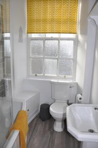 een badkamer met een toilet, een wastafel en een raam bij Emahroo Cullen in Cullen
