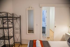1 dormitorio con cama y espejo en Bordador Bicycle City Center by Valcambre, en Sevilla