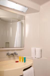 y baño con lavabo y espejo. en Hotel Cerise Lens, en Noyelles-Godault