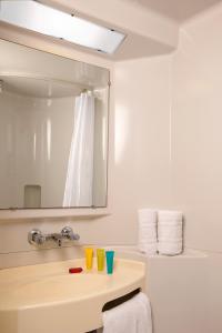 a bathroom with a sink and a mirror at Hotel Cerise Lens in Noyelles-Godault